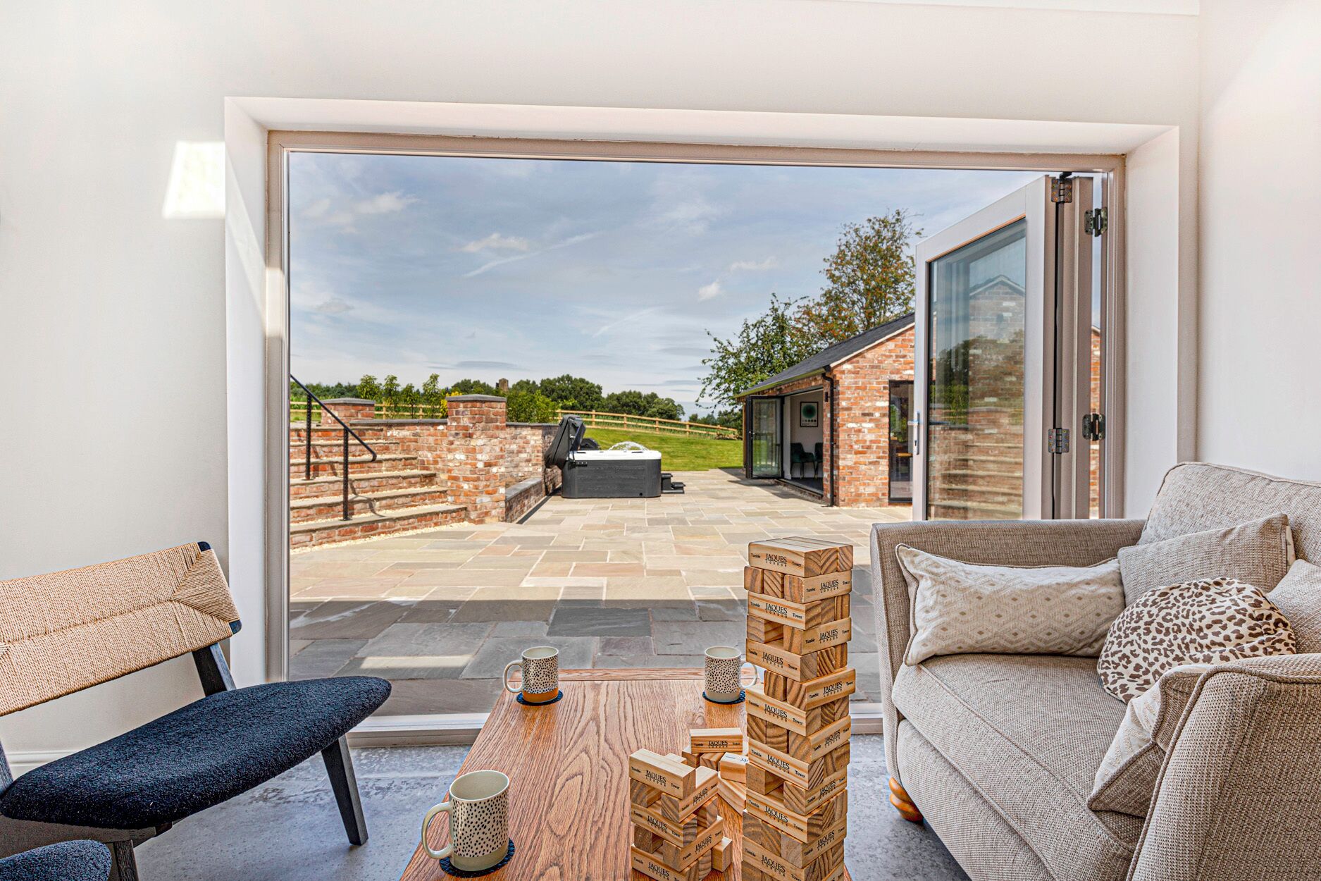 A modern living room with a glass door leading to an outdoor patio area.