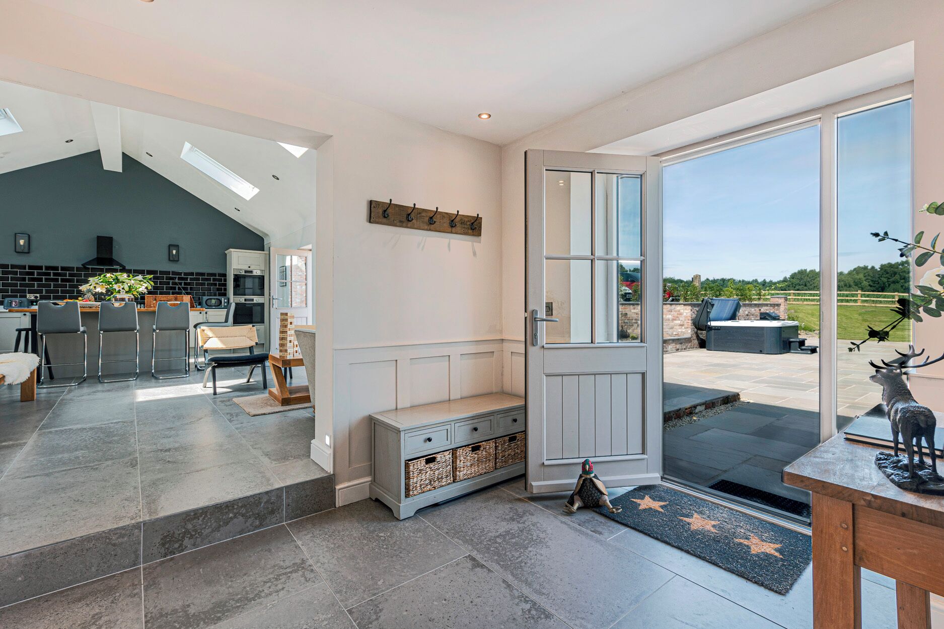A modern interior with a kitchen, dining area, and a large sliding glass door leading to an outdoor patio.