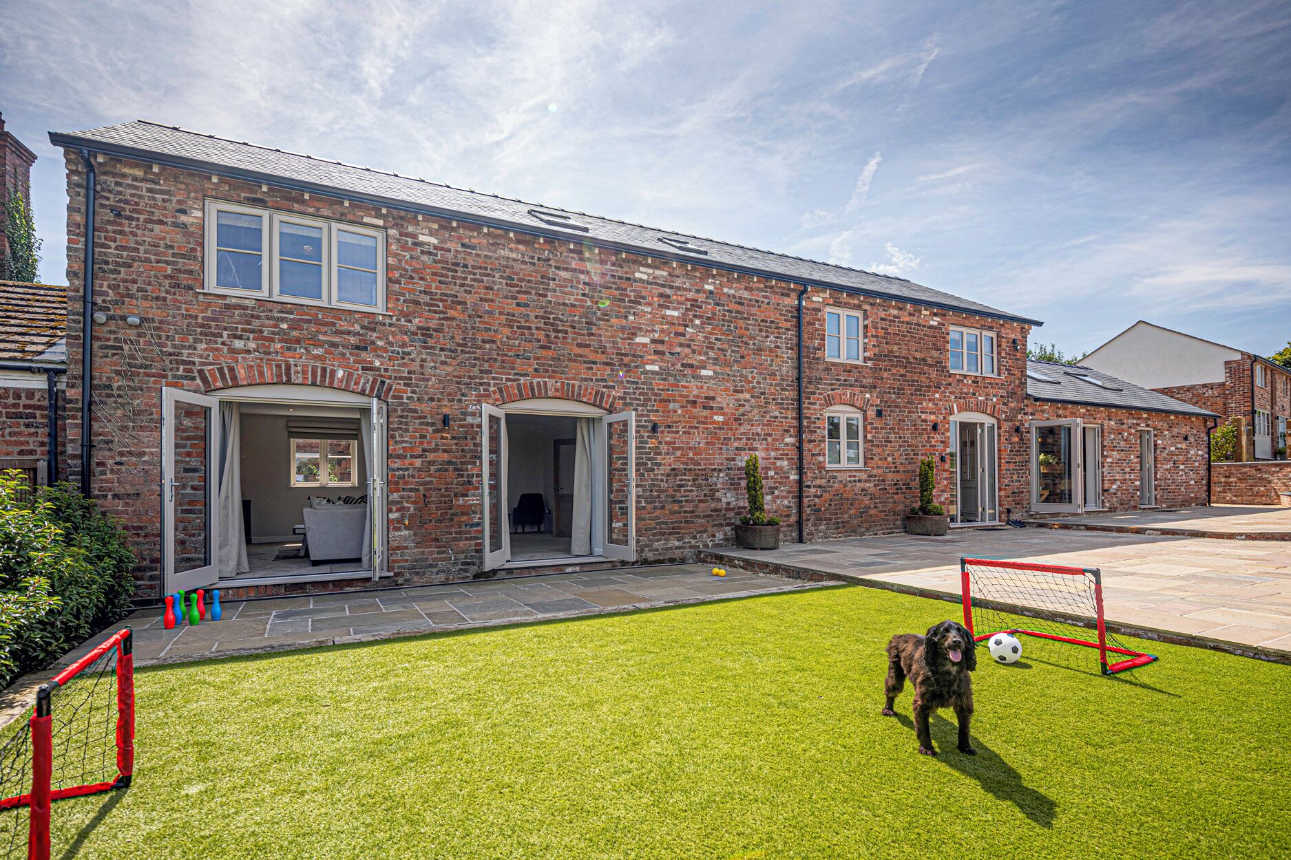 A brick house with a front yard and a soccer goal.