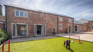 A brick house with a front yard and a soccer goal.