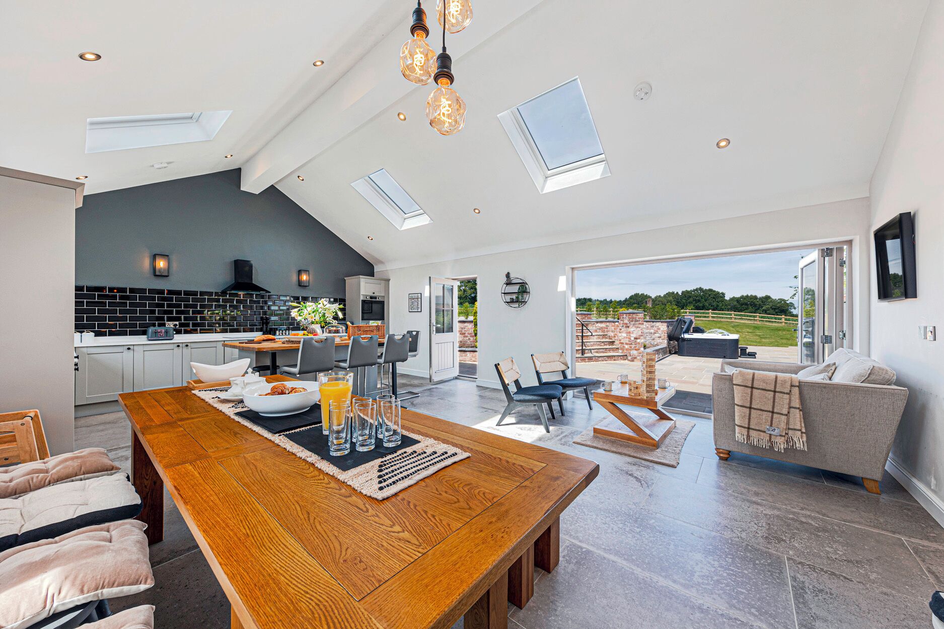 Una cocina espaciosa con comedor, una gran mesa de madera y vistas al exterior.