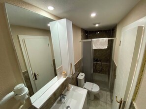 A bathroom with a large mirror, a sink, a toilet, and a shower enclosure. - Anjea Otel  (Çeşme)