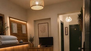 Zona de recepción con mostrador de madera, televisión y escritorio.