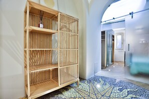 Ein modernes Interieur mit einer Holzbücherrege, einem Fliesenboden und einem Flur zu einem Raum mit Glastür.