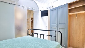 Um quarto com uma cama, um guarda-roupa e um armário.