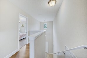 A hallway with a staircase leading to a bedroom. - Luxury Solterra Resort Retreat | Near Disney (Davenport)