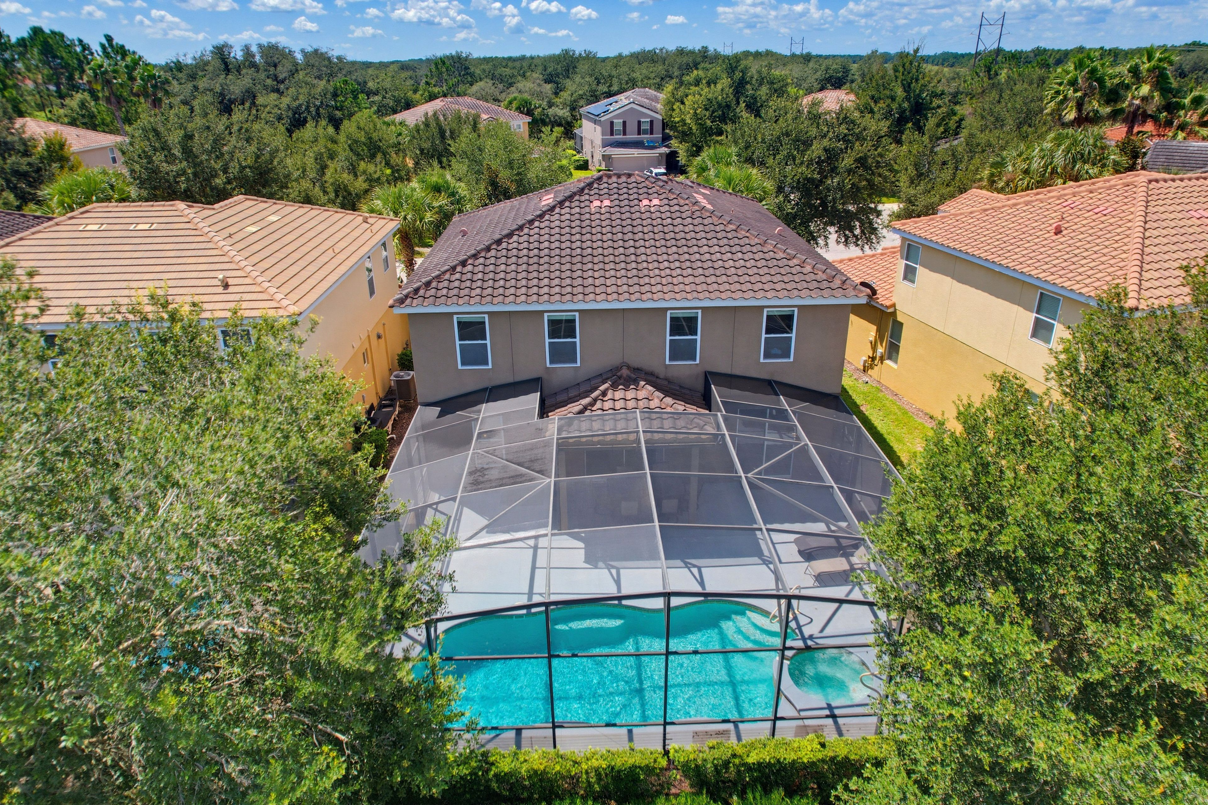 A residential area with houses, a swimming pool, and surrounding greenery.