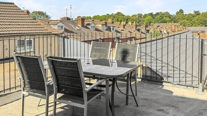 A rooftop terrace with a table and chairs, surrounded by a metal railing. - Sleeps 10 3 Bed Central Grantham with Parking (Grantham)