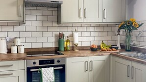 A kitchen with white cabinets, a built-in oven, and a wooden countertop. - Sleeps 10 3 Bed Central Grantham with Parking (Grantham)