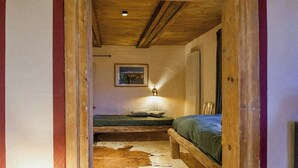 Ein schmaler Flur, der zu einem Schlafzimmer mit einem Bett und einem Nachttisch führt.