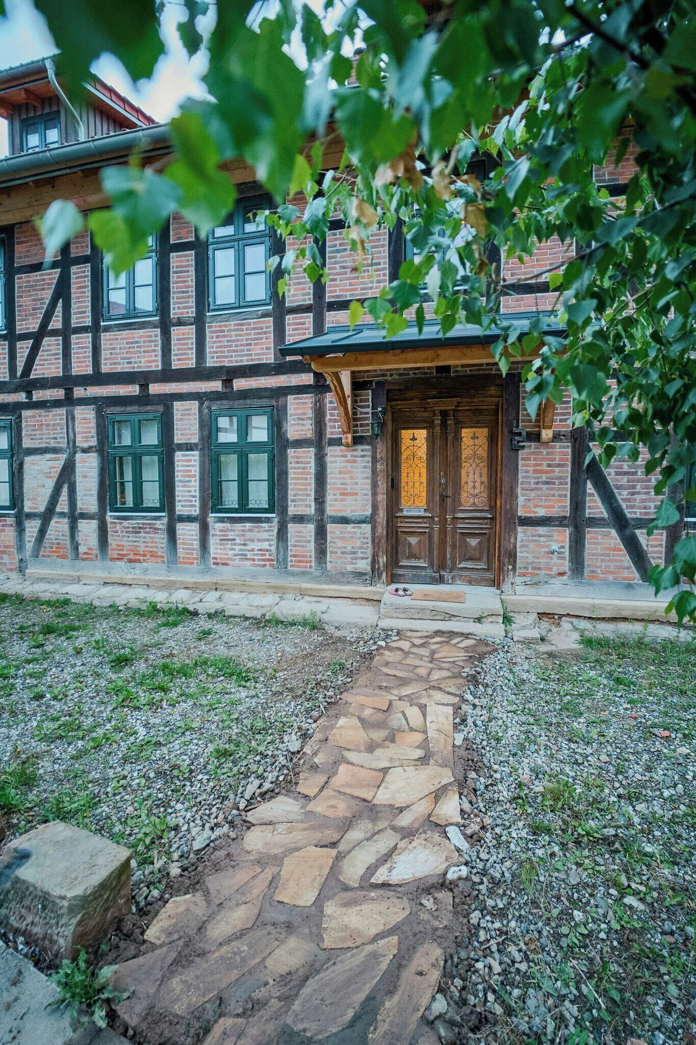 A traditional half-timbered building with a stone pathway leading to a wooden door.