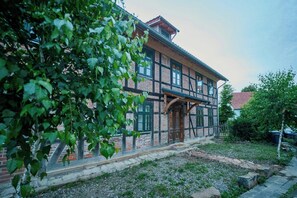 Ein traditionelles Fachwerkhäuschen mit Steinuntergrund, einer Holztür und einem Ziegelkamin.