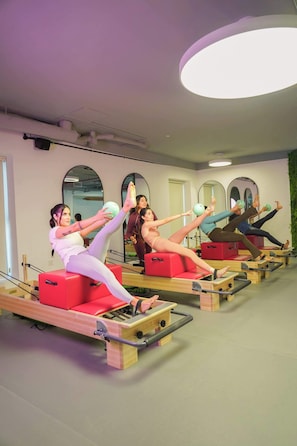 A Pilates studio with equipment and mirrors. - Tranquil Wellness Stay  Modern Hotel Apartment (Jumeirah Village Triangle)