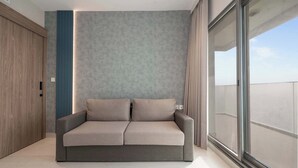 Ein modernes Wohnzimmer mit einer Couch, einem Holzschrank und einem großen Fenster.