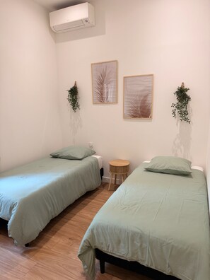 A room with two single beds, a small round table, and two wall-mounted plants. - Design & BBQ - Garden Terrace - 78 m² (Cagnes-sur-Mer)