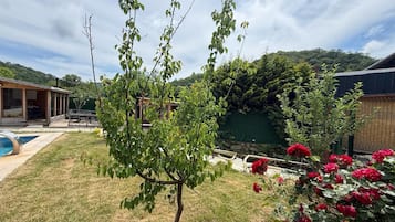 Una propiedad residencial con piscina, patio y jardín con plantas en flor.