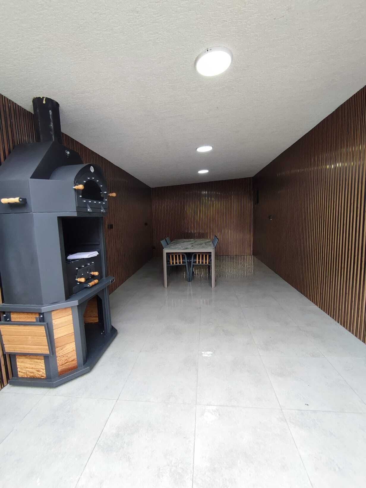 Una cocina moderna con horno empotrado, una mesa de comedor y piso de baldosas.