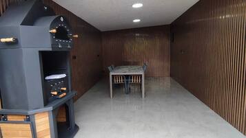 Una cocina moderna con horno empotrado, una mesa de comedor y piso de baldosas.
