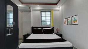Ein modernes Schlafzimmer mit einem Bett, Nachttischen, einem Spiegel und Kunstwerken an der Wand.
