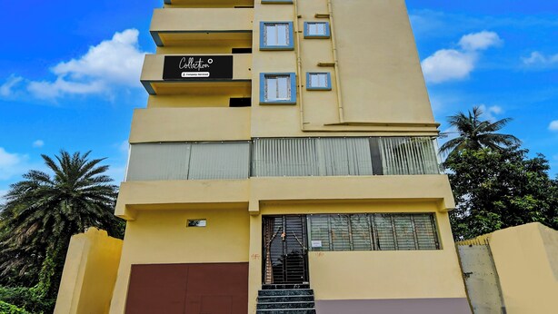 Ein mehrstöckiges Hotel mit flacher Fassade, Balkonen und einem Eingangsbereich mit Treppe.