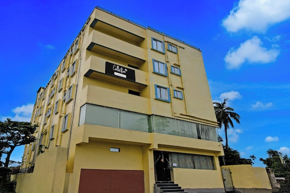 A multi-story building with a sign indicating it is a company-serviced collection.