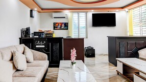 Ein stilvolles Wohnzimmer mit einer Couch, einem Couchtisch, einem Fernseher und einem Empfangstresen.