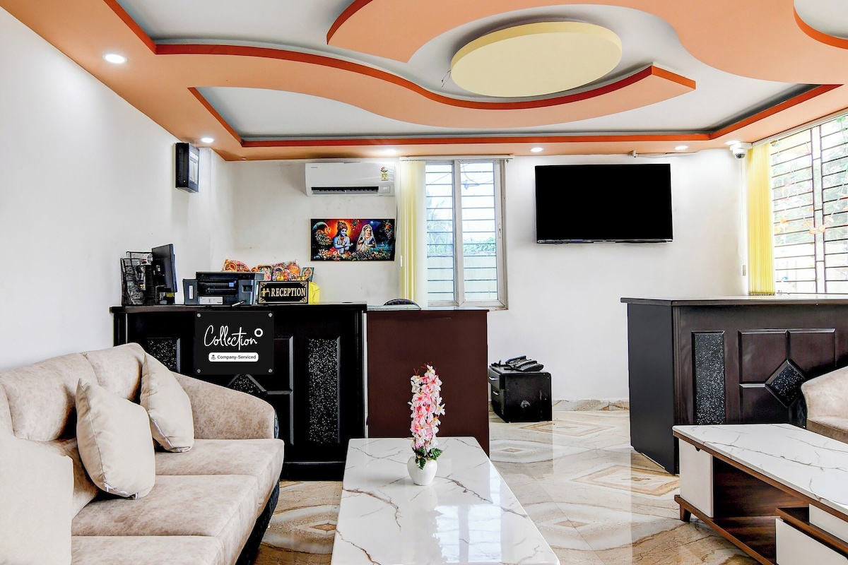 Un soggiorno moderno con un divano, un tavolino, una TV e una scrivania della reception.
