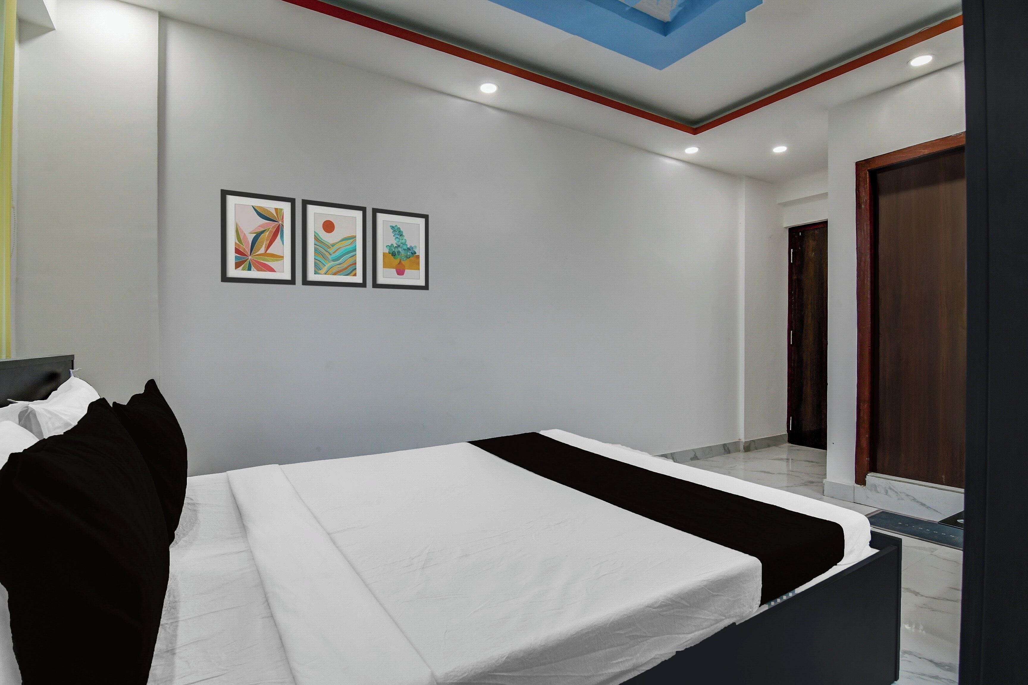 A bedroom with a bed, a nightstand, and a wall-mounted shelf.