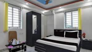 Ein modernes Hotelzimmer mit Bett, Nachttisch und Schreibtisch mit Stuhl.