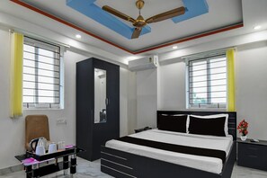 Una camera d'albergo moderna con un letto, un comodino e una scrivania con una sedia.