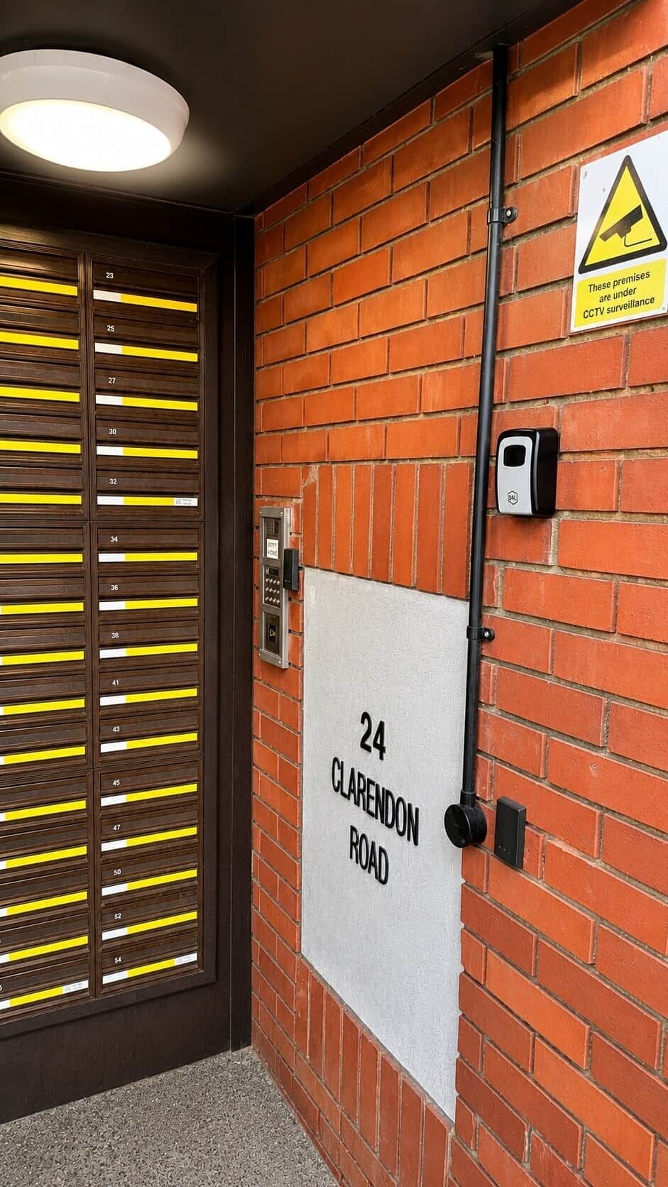 A door with numbered room panels, a street sign, and a CCTV warning sign.