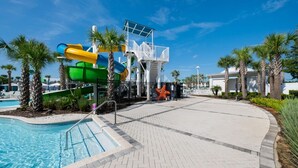 Un área de piscina con tobogán y torre de salvavidas.