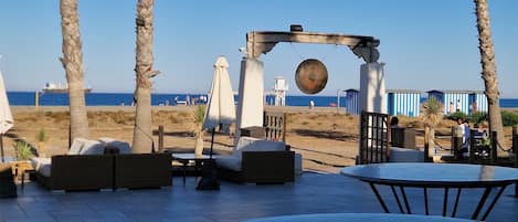 An outdoor seating area with a view of the beach and ocean.