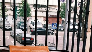 En lille udendørs siddeplads med to orange stole og et rundt bord.