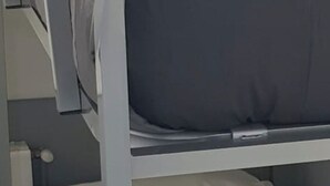 En køjeseng med hvid sengetøj og et foldet hvidt håndklæde i den nederste køje.