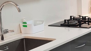 Et moderne køkken med vask, armatur og gasblus.