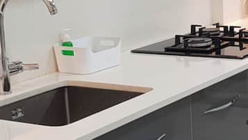 Une cuisine moderne équipée d’un évier, d’un robinet et d’une cuisinière à gaz.
