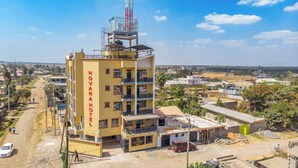 A multi-story hotel with balconies and a prominent tower structure. - Novara Hotel Mwihoko  (Nairobi)