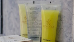 A bathroom shelf with two toiletries: a shower gel and a shampoo bottle. - Novara Hotel Mwihoko  (Nairobi)