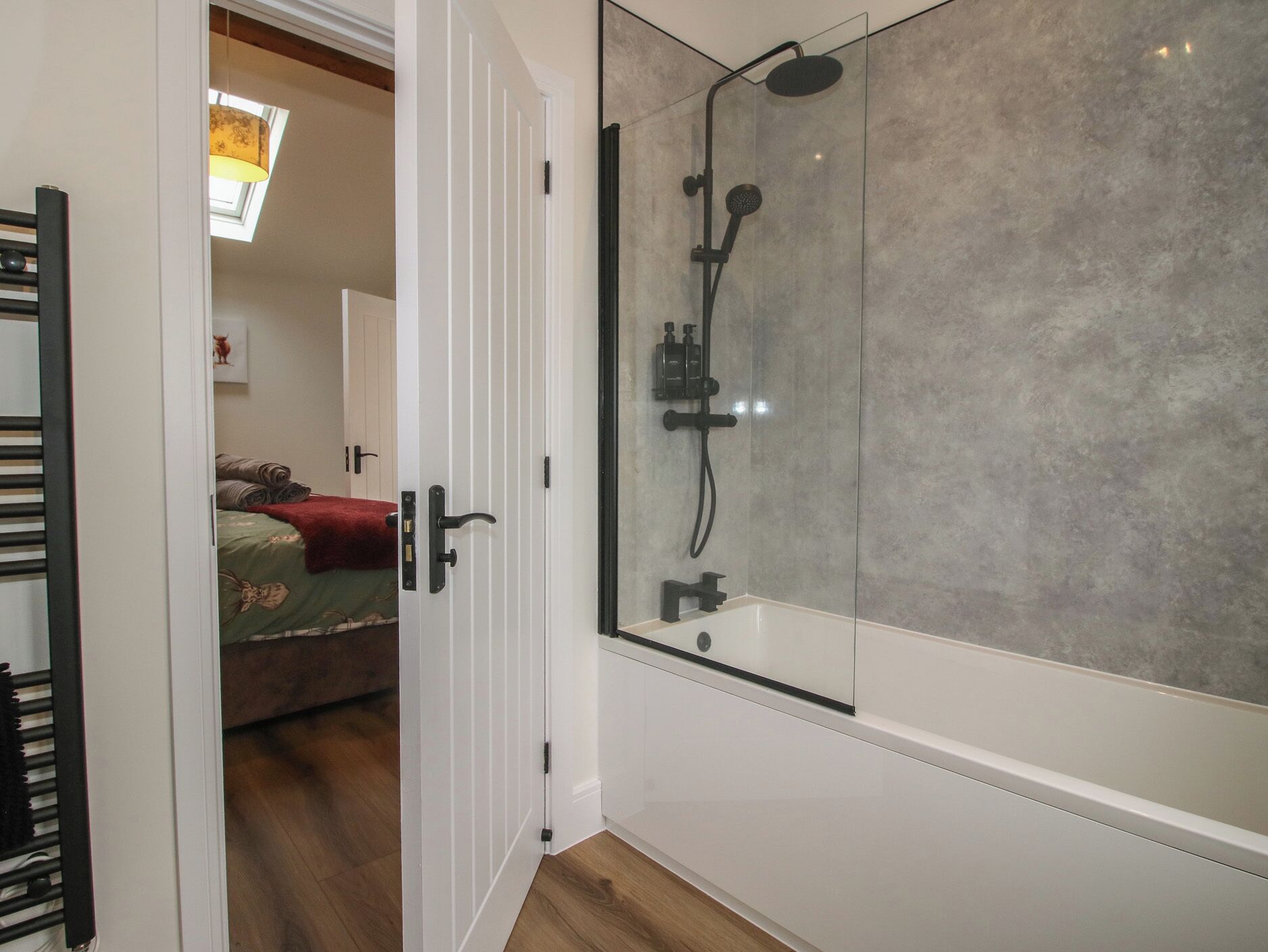 Un baño moderno con cabina de ducha de vidrio, ducha visible y bañera.