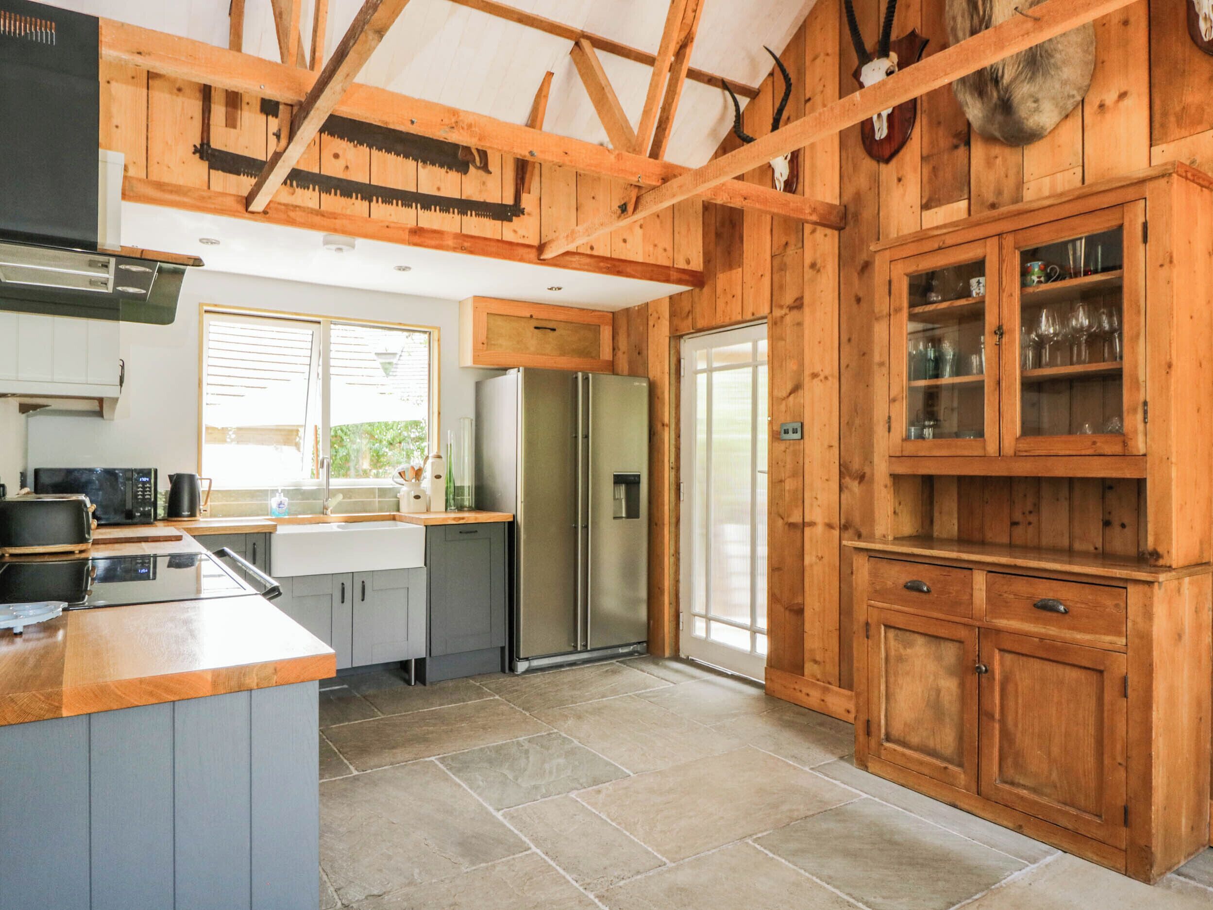 A kitchen with wooden cabinets, a refrigerator, and a window.
