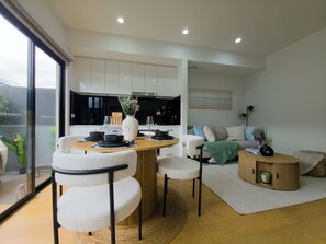 A modern living space with a dining area, kitchen, and seating area. - The St Kilda Edit - Luxury 2BR Home Minutes to Beach (St Kilda)