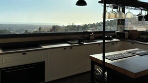 Una cucina con vista sul paesaggio, dotata di lavello, pensili e un piano di lavoro con elettrodomestici.