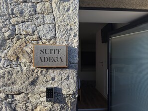 A stone wall with a sign reading 'SUITE ADEGA' and a keypad lock.