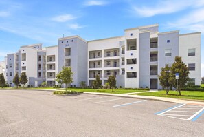 A multi-story residential building with a parking lot in front. - Lake vista condo #201 - newly remodeled (Kissimmee)