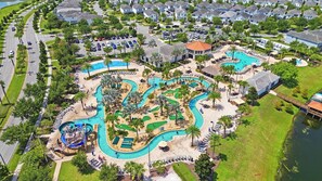 An aerial view of a resort with multiple swimming pools, a water park, and a residential area with houses. - Lake vista condo #201 - newly remodeled (Kissimmee)