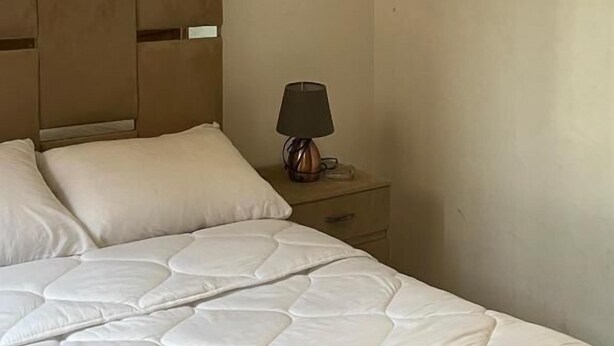A hotel room with a bed, a nightstand, and a lamp. - Riad Flouris in marrakech (Marrakech)