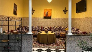 A room with a patterned carpet, a round table, and a sofa set. - Riad Flouris in marrakech (Marrakech)