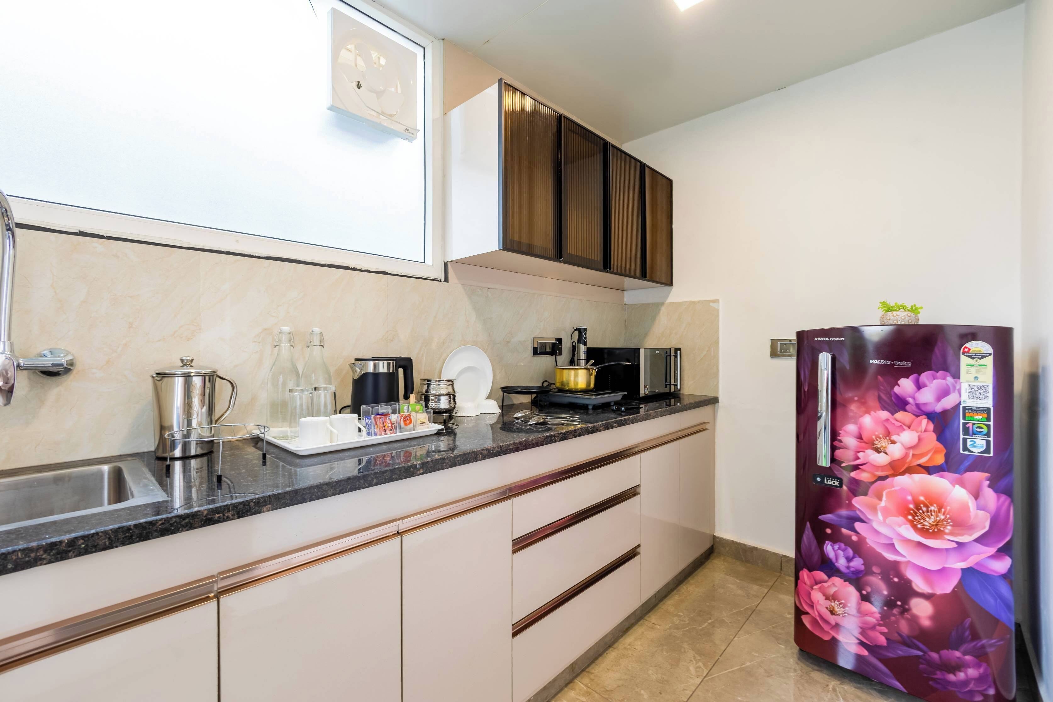 A modern kitchen with a built-in refrigerator, stainless steel appliances, and a marble countertop.