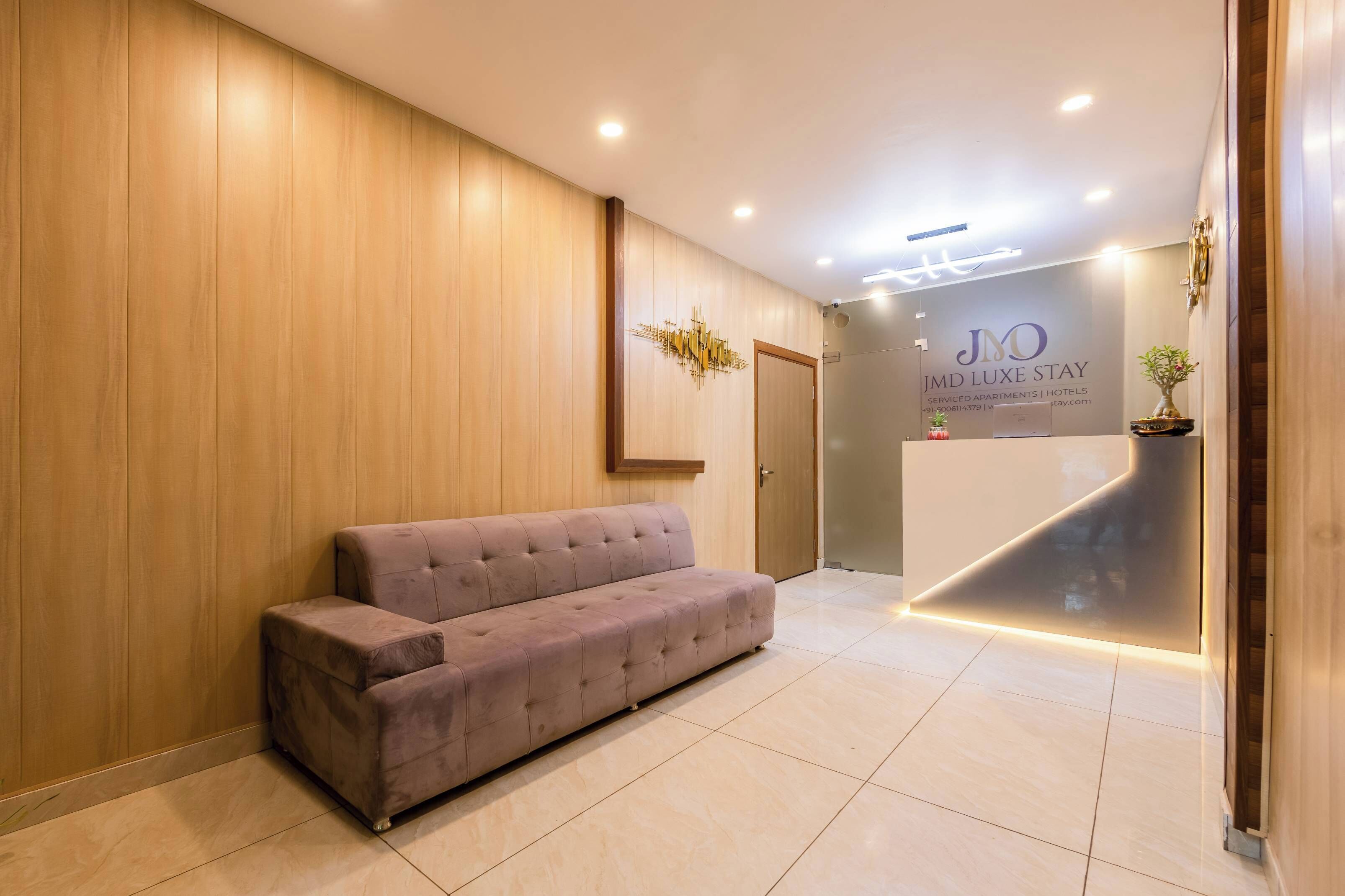 A reception area with a wooden wall, a reception desk, and a cushioned bench.